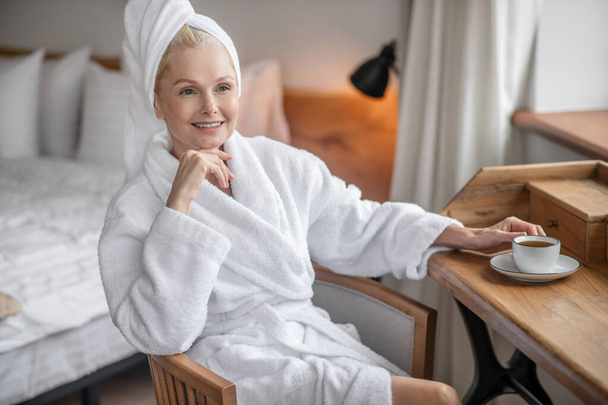 A pretty woman resting after the shower and looking happy - Foto, afbeelding