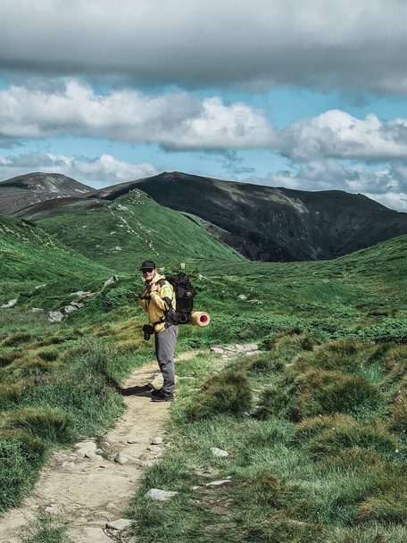 young hiker man in mountains. summer trekking path. copy space. - Photo, image
