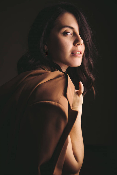 стиль чувственный портрет молодой потрясающей женщины в коричневой куртке студийный свет - Фото, изображение