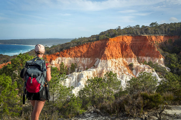 Kobieta podróżnik bierze w widoki na niesamowite Pinnacles formacji spektakularne erozji funkcji, która składa się z klifów miękkich białych piasków pokrytych warstwą czerwonego żwiru gliny. Została złożona w okresie geologicznym trzeciorzędu.  - Zdjęcie, obraz