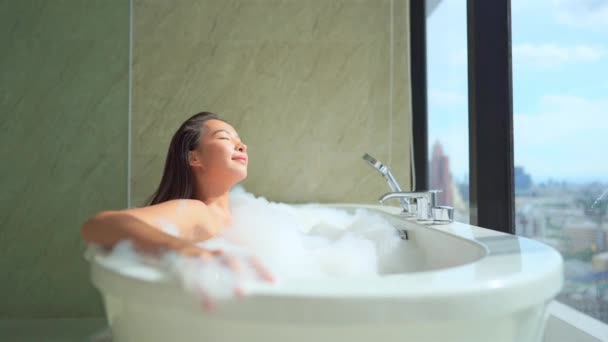 πλάνα από όμορφη Ασιάτισσα γυναίκα που κάνει μπάνιο με σαπουνόφουσκες - Πλάνα, βίντεο