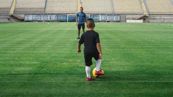 Negro padre pateando pelota de fútbol a hijo - Foto, Imagen