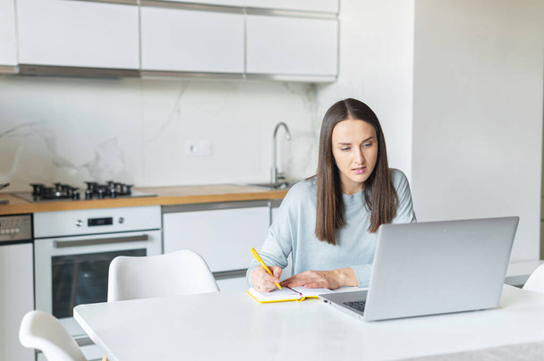 Charming young woman using laptop computer for working from home - Photo, Image