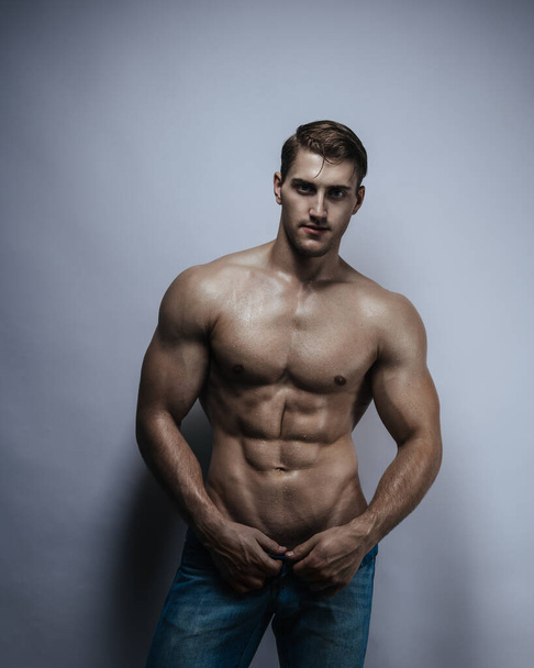 Studio portrait of shirtless young man in jeans - Foto, Imagem