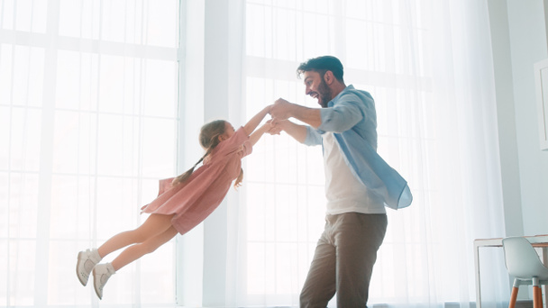 Mladý otec krouží kolem malé dcery v interiéru domova - Fotografie, Obrázek