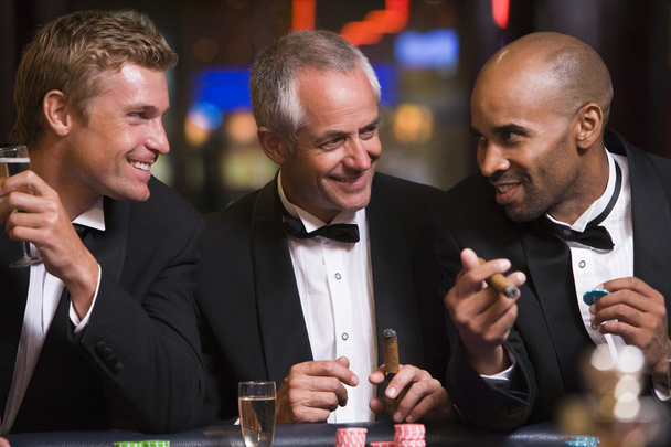 drie mannen op roulettetafel in casino gokken - Foto, afbeelding