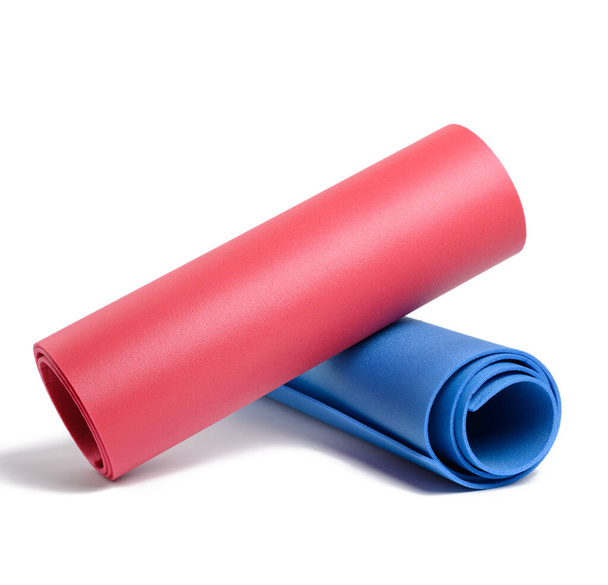 Rote und blaue Neoprenteppiche isoliert auf weißem Hintergrund. Sportmatte - Foto, Bild