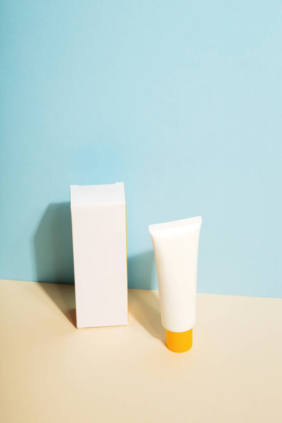 White tube and box of sunscreen on blue background. Sun Protection. Copy space - Foto, Bild