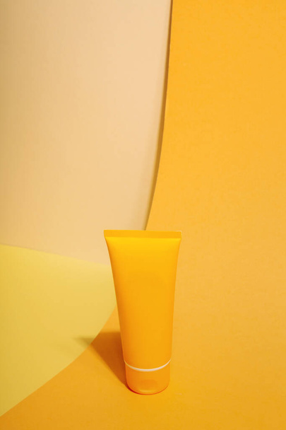 Orange tube of sunscreen on orange background. Sun Protection. Copy space - Photo, Image