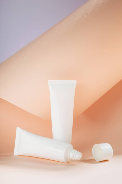 White tubes moisturizers creams on beige background. Copy space. Set for skinbeauty products - Фото, изображение
