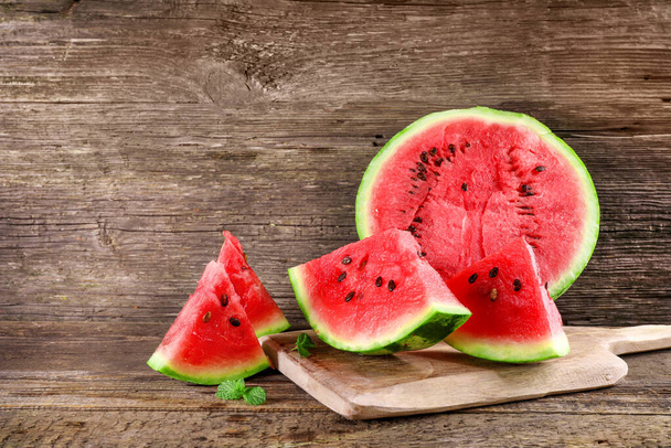 Ripe juicy watermelon pieces on wooden background. - Photo, Image