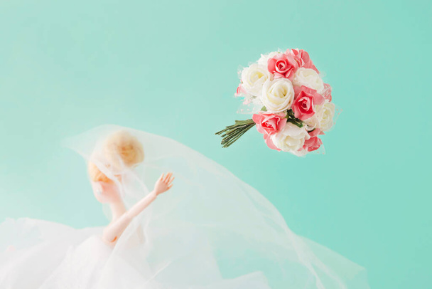 A bride who throws a Biedermeier. The wedding. A woman's moment. Blue background. Minimal composition. - Φωτογραφία, εικόνα