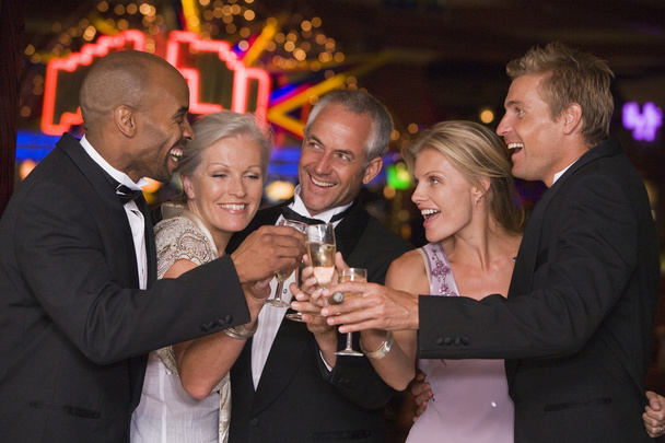 Group of friends celebrating with champagne in casino - Foto, Imagem
