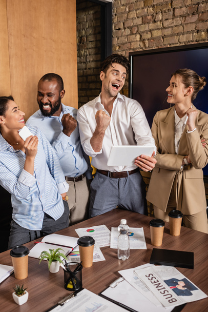 succesvolle interraciale zakenpartners tonen win gebaar in vergaderzaal - Foto, afbeelding