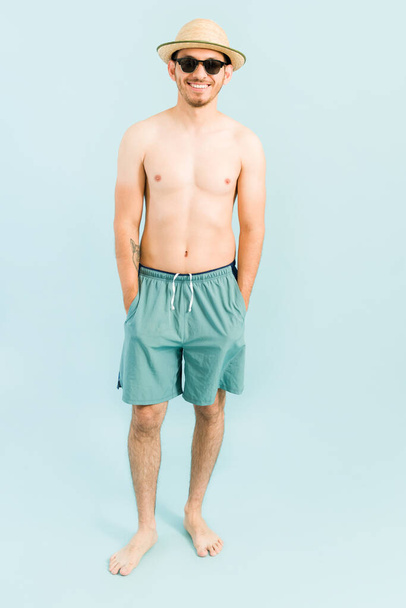 Během letních prázdnin se cítím uvolněně. Hispánec mladý muž těší svůj čas u bazénu a připraven vyrazit na pláž - Fotografie, Obrázek