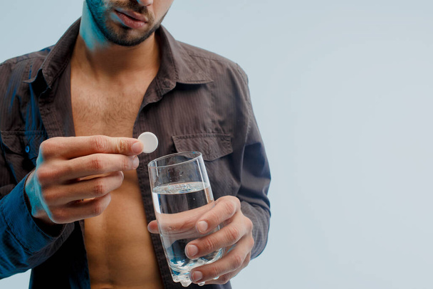 Ember dobja tabletta üveg vízzel, közelről - Fotó, kép