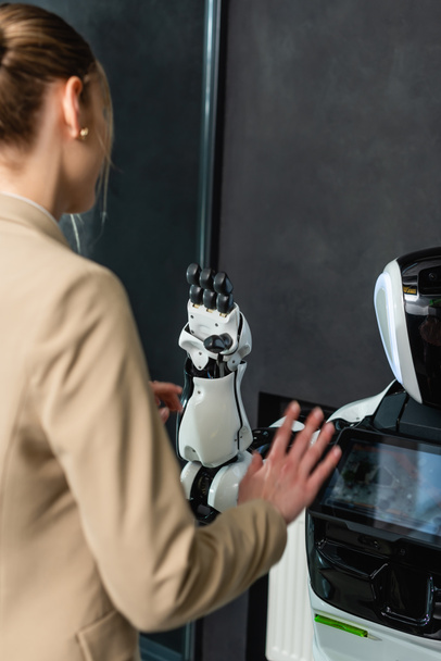 junge Geschäftsfrau berührt Roboter im Büro - Foto, Bild