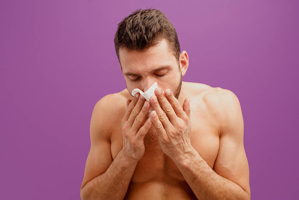 Epäterveellinen mies käyttää nenäliinaa nenän vuotamiseen - Valokuva, kuva