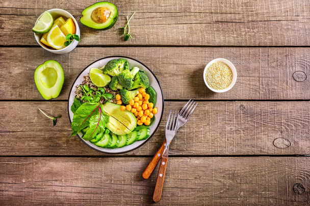Egészséges vegetáriánus ételkoncepció: quinoa zöldségekkel, magokkal és fűszernövényekkel fa alapon. Felülnézet. - Fotó, kép