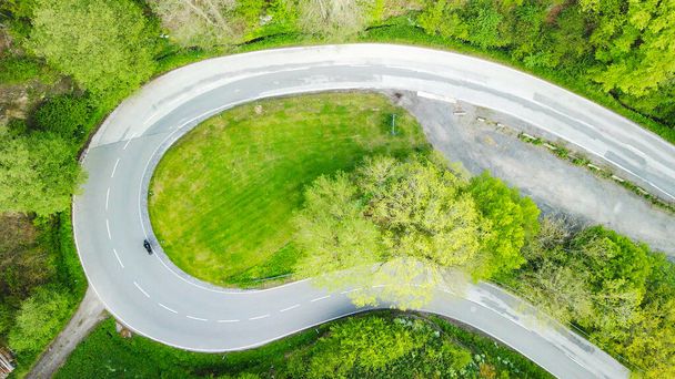 Vista aérea de uma curva através da qual uma motocicleta e carros estão indo - Foto, Imagem