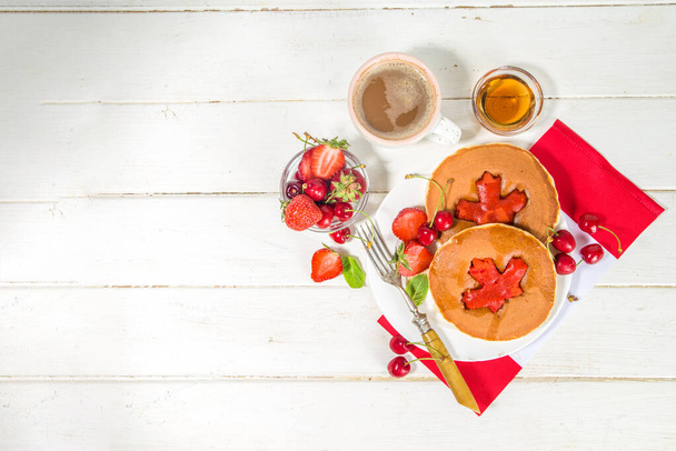 Canada Day concept, brunch menu achtergrond. Stapel rode en witte pannenkoeken met esdoorn blad creatieve decoratie, idee voor Canada Dag ontbijt voedsel  - Foto, afbeelding