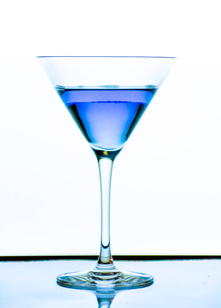Cocktail glass with blue beverage on white background - Photo, Image