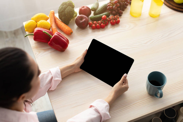 Mujer usando tableta con pantalla vacía para maqueta en la mañana - Foto, imagen
