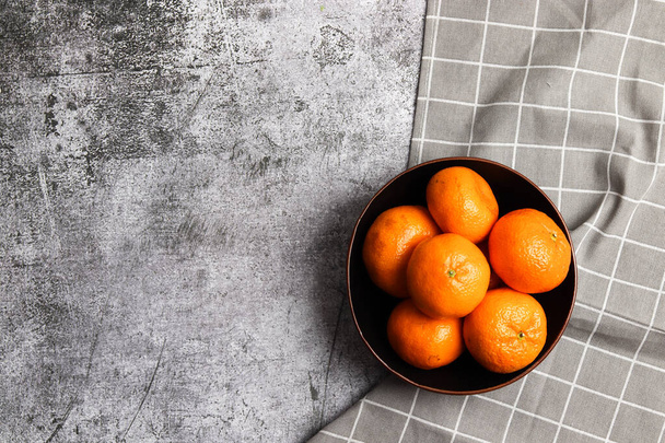 Tangerines in a bowl on a dark grey background. Top view, flat lay - Foto, Imagem