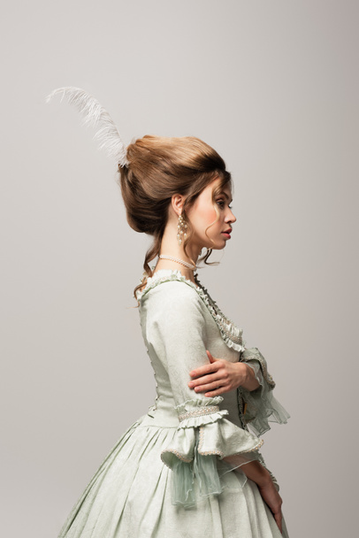 side view of elegant woman in retro outfit posing isolated on grey - Valokuva, kuva