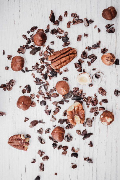A vertical top view of nuts and chocolate chips on a kitchen table - 写真・画像