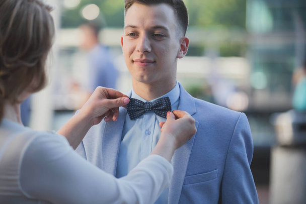 A female fixing her boyfriend's bow tie - Valokuva, kuva