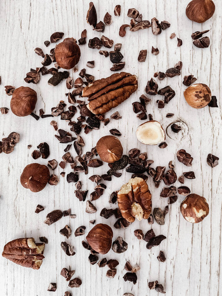 A vertical top view of nuts and chocolate chips on a kitchen table - Valokuva, kuva