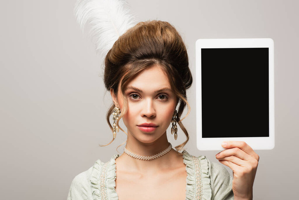 Vintage-Stil Frau hält digitale Tablette mit leerem Bildschirm isoliert auf grau - Foto, Bild