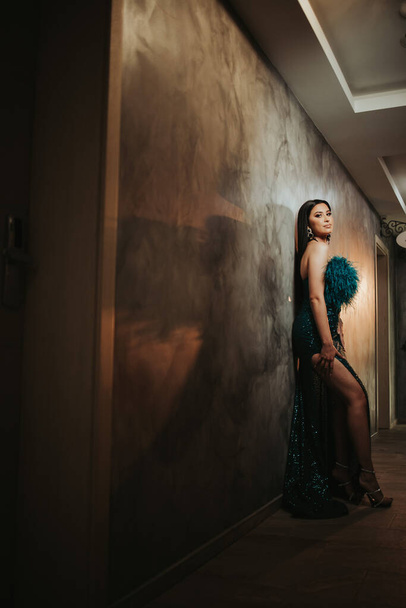 A Caucasian female with a gorgeous turquoise dress posing in a corridor - Фото, изображение