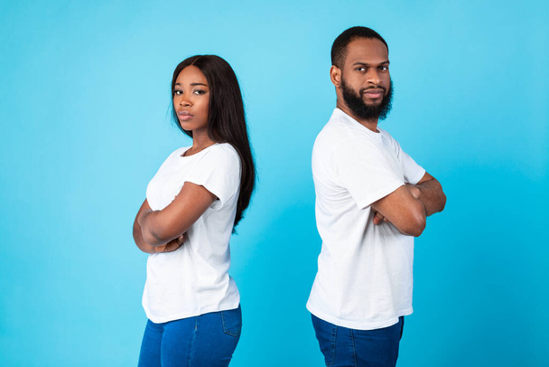 Afro ζευγάρι στέκεται πλάτη με πλάτη, μπλε φόντο στούντιο - Φωτογραφία, εικόνα