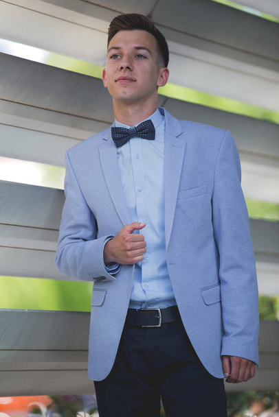 A young handsome elegant man in a blue suit and bow - Fotografie, Obrázek