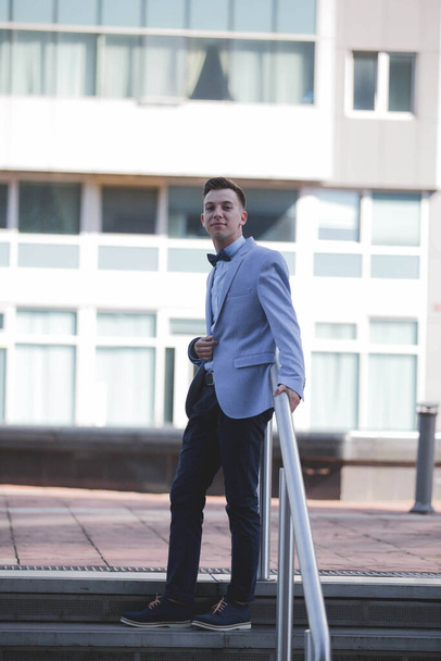 A vertical shot of a Caucasian male with a suit posing outdoors - Foto, imagen