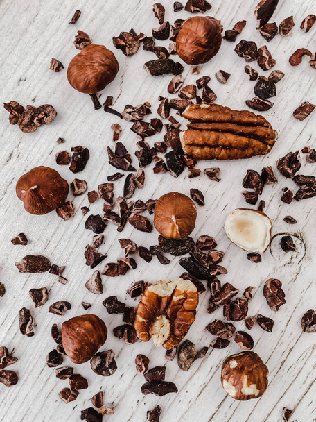 A vertical top view of nuts and chocolate chips on a kitchen table - 写真・画像