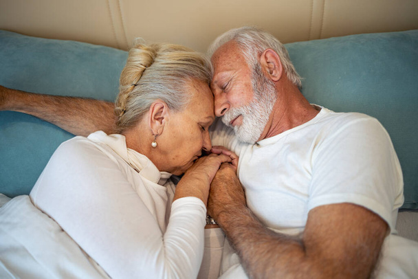 Retrato de feliz pareja de ancianos en el dormitorio en casa. hombre y mujer inferior durmiendo. - Foto, Imagen