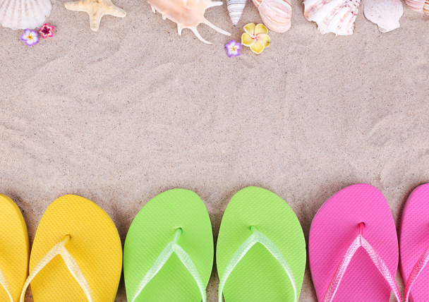 heldere slippers op zand, close-up - Foto, afbeelding