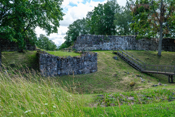 ruïnes van oude stenen kasteel in groene zomerweide - Foto, afbeelding