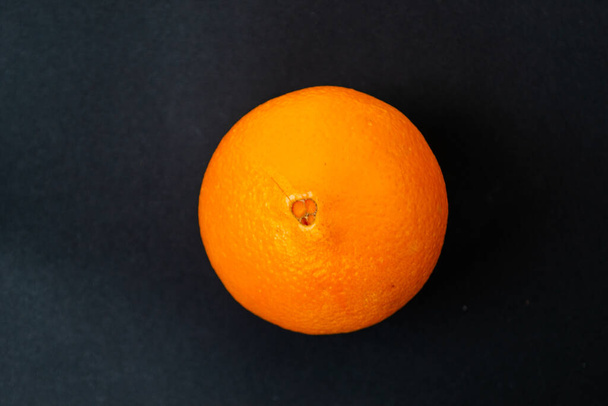 Спелый апельсин на черном фоне и меловой доске. Копирование пространства. - Фото, изображение