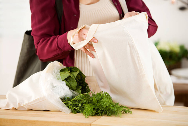 Series with a woman unpacking groceries and using reusable fabric bags. - Φωτογραφία, εικόνα