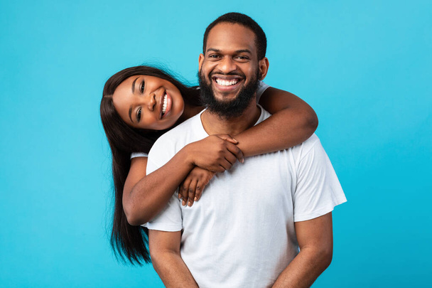 Afro-Amerikaanse man met baard knuffelt met zijn vrouw - Foto, afbeelding