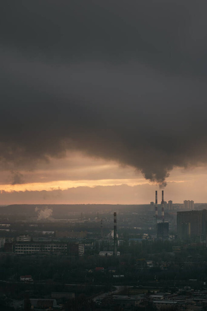Ecology factory chimney in the Kyiv Ukraine. Pollution of air, orange sky before sunset. - Photo, Image