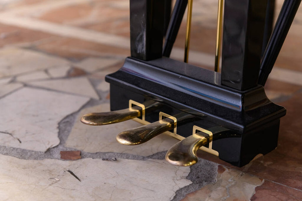 golden piano pedals of a concert grand piano standing on concert stage - 写真・画像