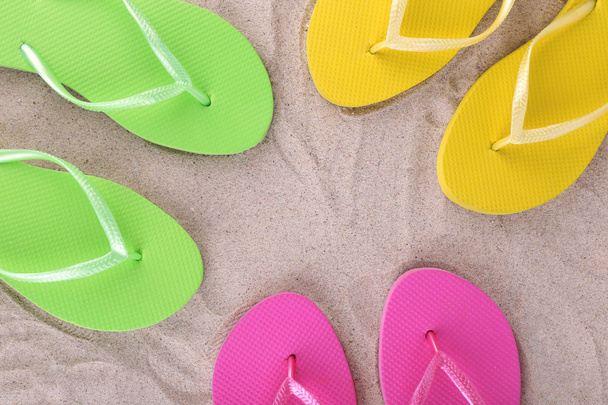 Bright flip-flops on sand, close up - Photo, Image