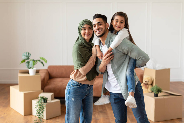 Heureuse famille musulmane regardant la caméra, posant le jour du déménagement - Photo, image