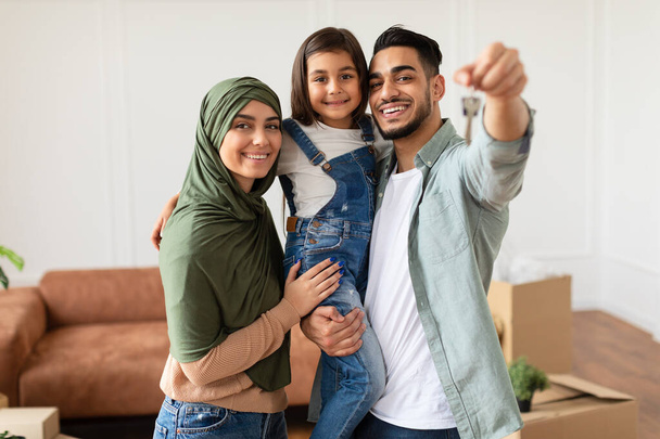 Χαρούμενη μουσουλμανική οικογένεια δείχνει τα κλειδιά του διαμερίσματός τους - Φωτογραφία, εικόνα