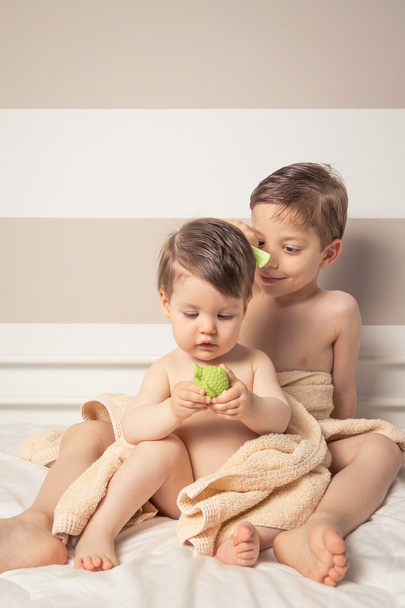 Sweet boy combing little girl in a bed after bath - Zdjęcie, obraz